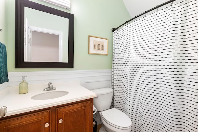 bathroom featuring vanity, toilet, curtained shower, and lofted ceiling