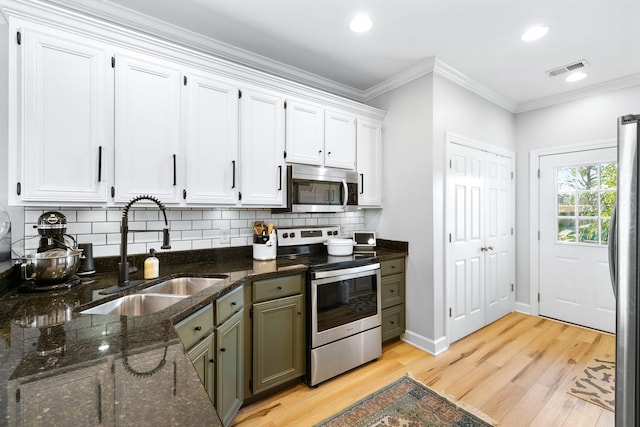 kitchen with sink, white cabinets, light wood-type flooring, and stainless steel appliances