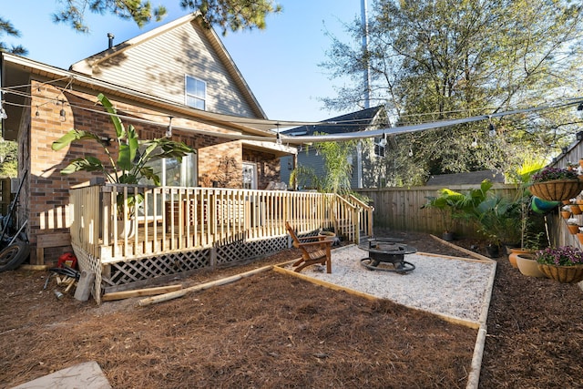 rear view of house featuring a fire pit and a wooden deck