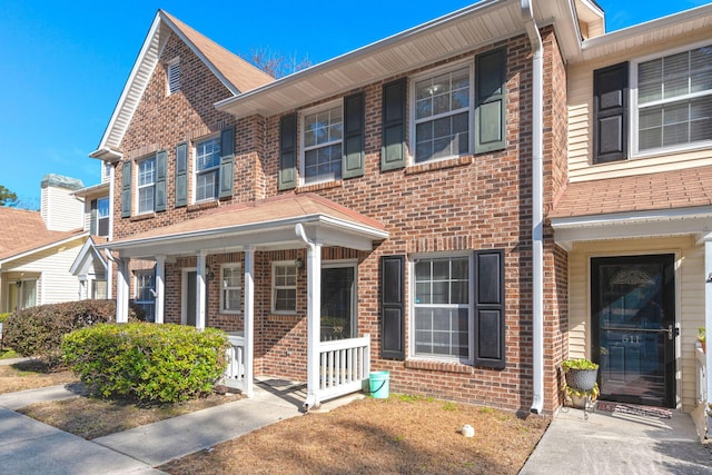 multi unit property featuring a porch and brick siding