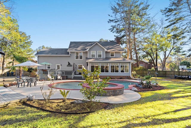 back of property with a swimming pool with hot tub, a lawn, a patio area, and a sunroom