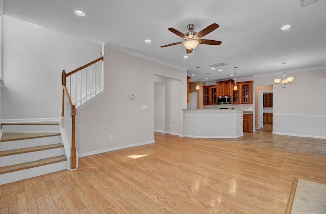 unfurnished living room with crown molding, ceiling fan with notable chandelier, and light hardwood / wood-style flooring