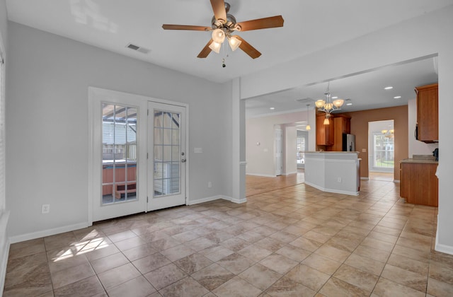 interior space featuring ceiling fan with notable chandelier and light tile floors