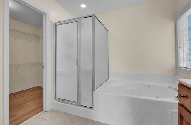 bathroom with wood-type flooring, separate shower and tub, and vanity