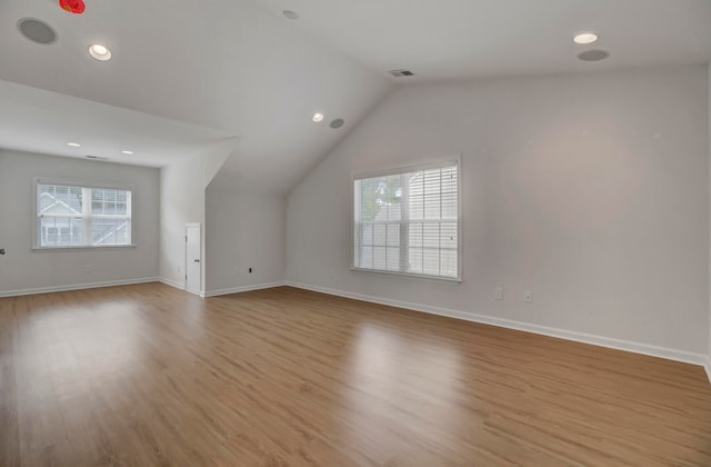 bonus room featuring light wood-type flooring and vaulted ceiling