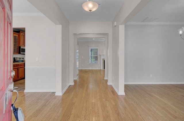 corridor featuring ornamental molding and light hardwood / wood-style floors