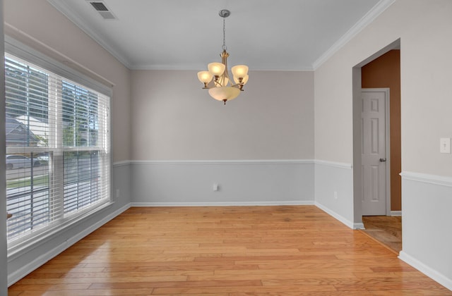 unfurnished room with a notable chandelier, ornamental molding, and light wood-type flooring