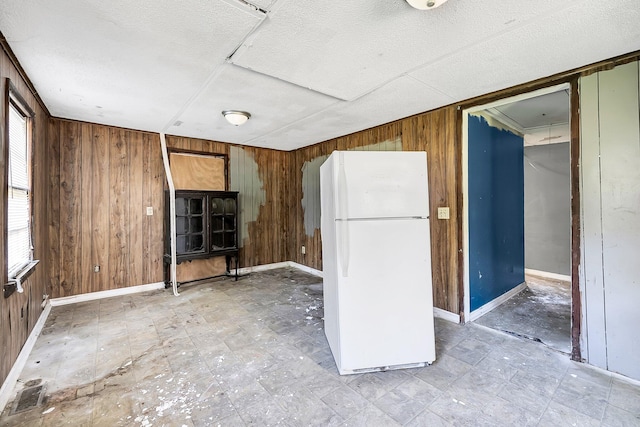 kitchen with white refrigerator and wood walls