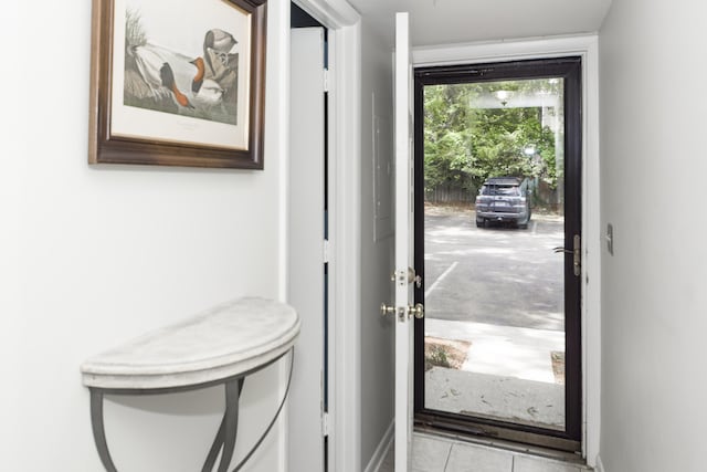 doorway to outside with light tile patterned flooring