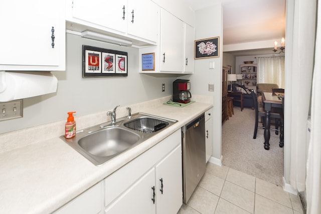 kitchen with a notable chandelier, dishwasher, sink, white cabinets, and light colored carpet