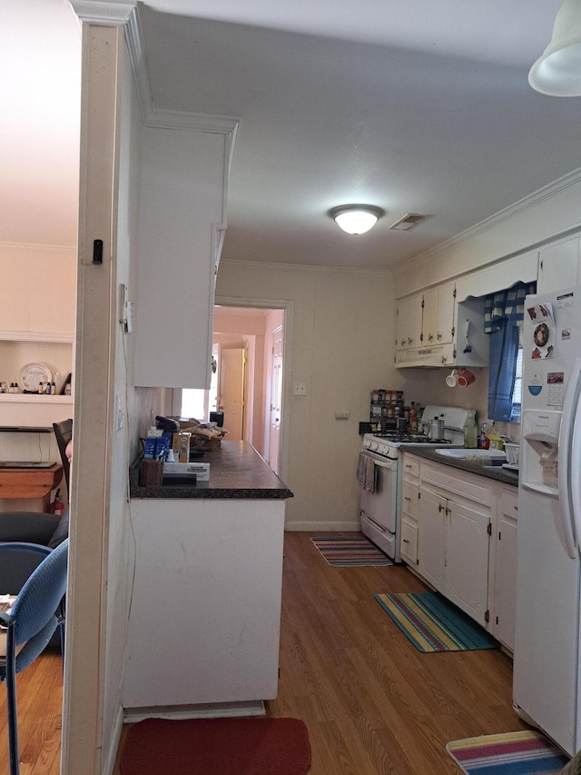 kitchen featuring dark hardwood / wood-style flooring, white cabinets, white appliances, and sink