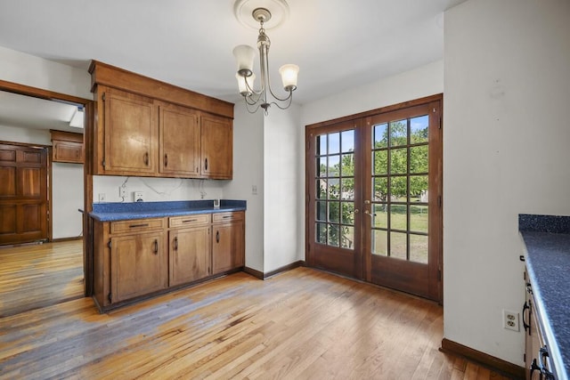 305 Whitewood Ct, Moncks Corner, SC 29461 - kitchen featuring french doors, dark countertops, brown cabinetry, light wood-style flooring, and baseboards