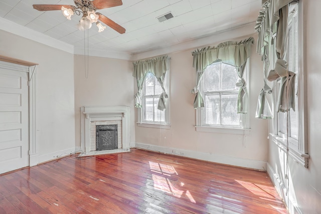 unfurnished living room with a brick fireplace, crown molding, wood-type flooring, and ceiling fan