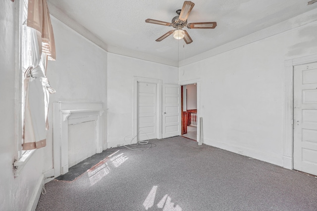 empty room featuring ceiling fan, carpet floors, and a textured ceiling