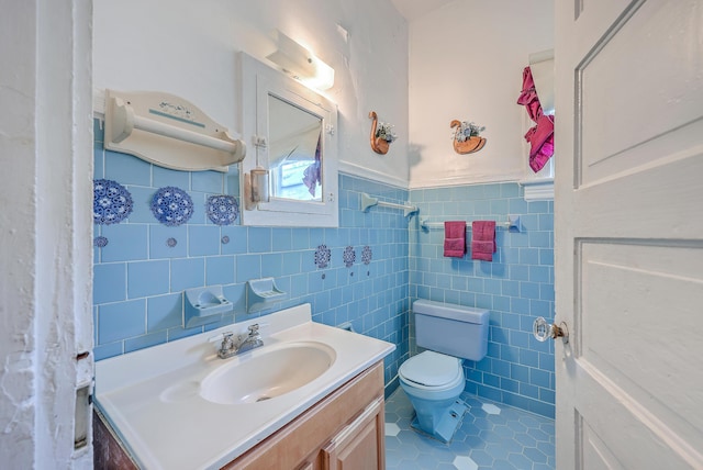 bathroom featuring toilet, tile patterned flooring, tile walls, and vanity