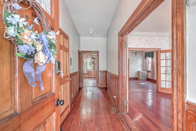 hallway featuring a textured ceiling, hardwood / wood-style floors, and radiator heating unit