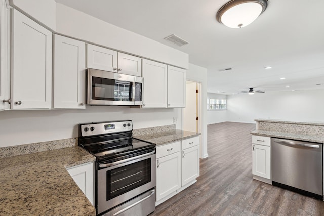 kitchen featuring white cabinetry, appliances with stainless steel finishes, dark wood-style floors, and visible vents