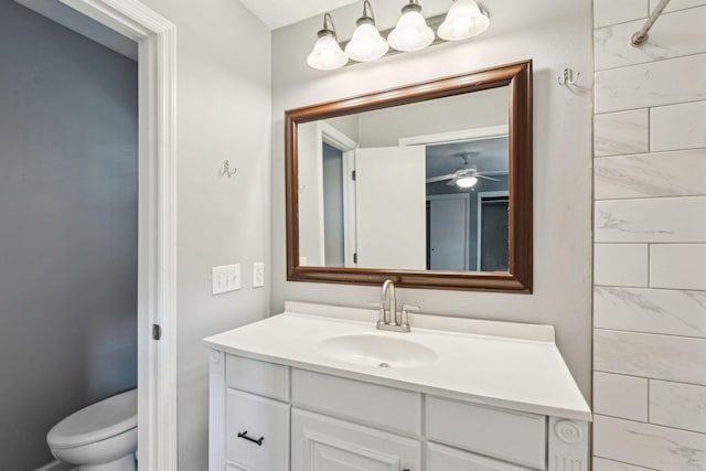 bathroom featuring a ceiling fan, toilet, and vanity