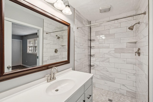 full bathroom with tiled shower and vanity