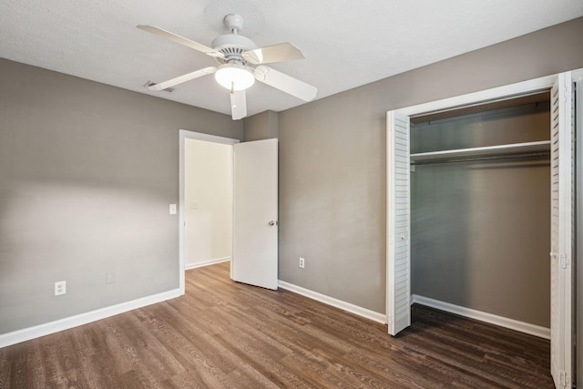 unfurnished bedroom featuring a closet, baseboards, ceiling fan, and wood finished floors