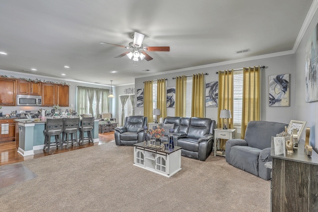 living room with visible vents, crown molding, a healthy amount of sunlight, and ceiling fan