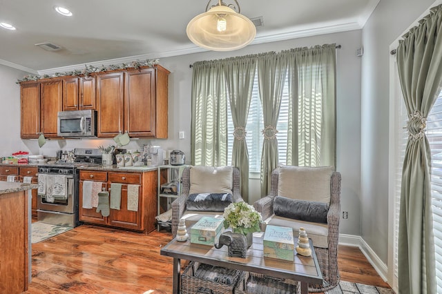 kitchen with brown cabinets, stainless steel appliances, and crown molding