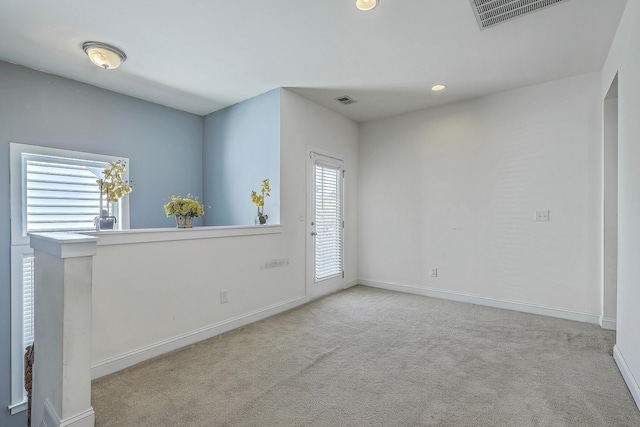 empty room featuring baseboards, visible vents, and carpet floors