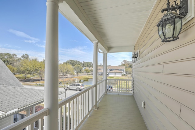 balcony with covered porch and a water view