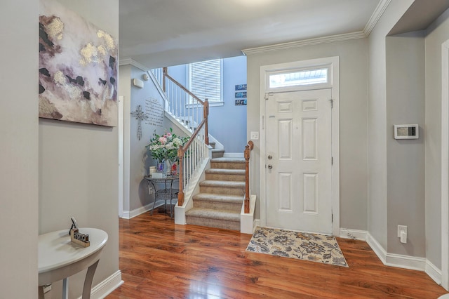 entrance foyer featuring baseboards, wood finished floors, stairway, and crown molding
