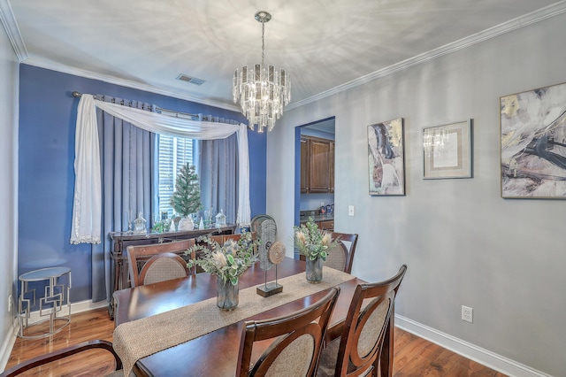 dining space with baseboards, crown molding, wood finished floors, and an inviting chandelier