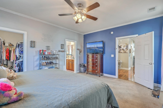 carpeted bedroom with baseboards, visible vents, ornamental molding, and a spacious closet