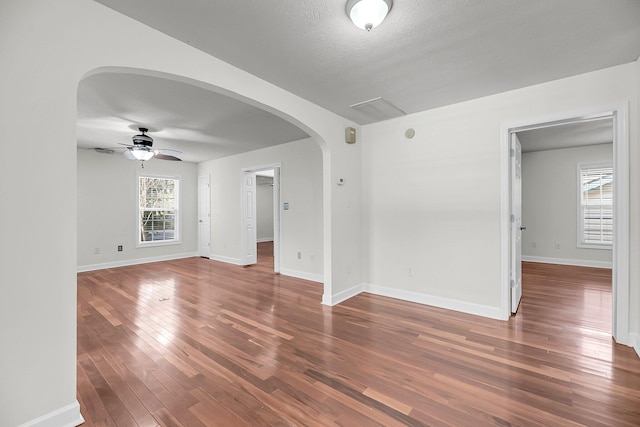 unfurnished room featuring a textured ceiling, dark hardwood / wood-style flooring, and ceiling fan