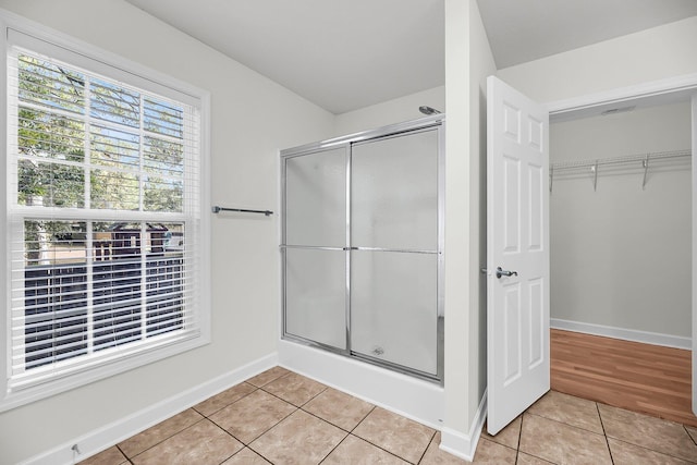 bathroom featuring tile patterned flooring and an enclosed shower