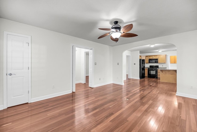 unfurnished living room with ceiling fan and hardwood / wood-style flooring