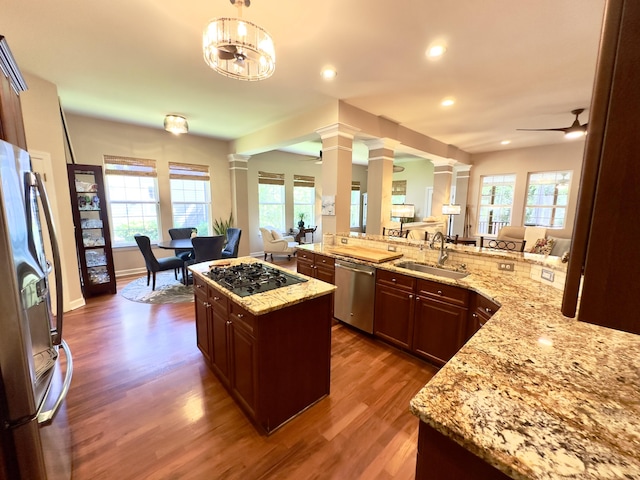 1736 James Basford Pl, Mount Pleasant, SC 29466 - kitchen featuring light stone counters, a sink, stainless steel appliances, decorative columns, and wood finished floors