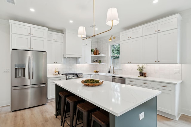 4620 Ohear Ave, North Charleston, SC 29405 - kitchen featuring appliances with stainless steel finishes, a sink, light wood-type flooring, custom range hood, and backsplash