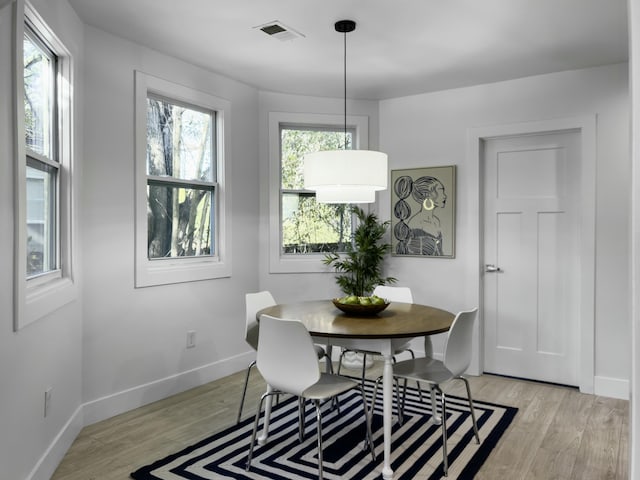 dining space with light wood-type flooring, baseboards, and visible vents