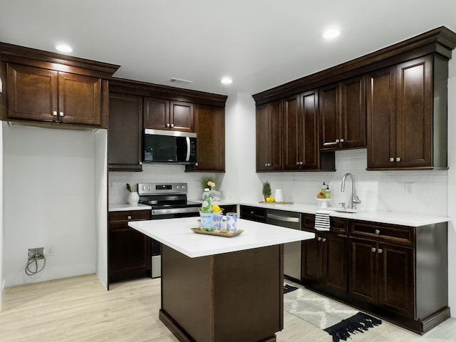 kitchen featuring decorative backsplash, stainless steel appliances, dark brown cabinets, light countertops, and a sink