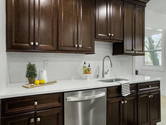 kitchen featuring dishwasher, dark brown cabinets, a sink, and light countertops