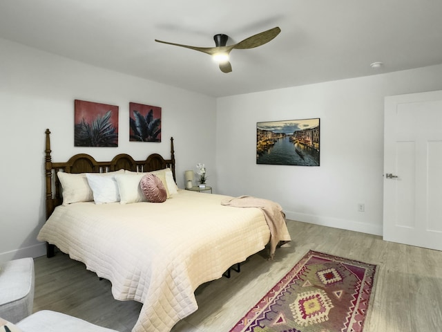 bedroom with light wood finished floors, ceiling fan, and baseboards