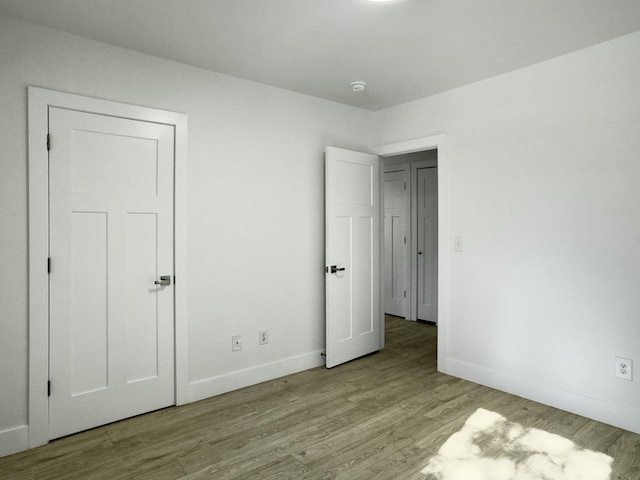 unfurnished bedroom with baseboards and wood finished floors