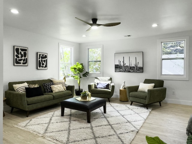 living area with recessed lighting, visible vents, baseboards, and wood finished floors