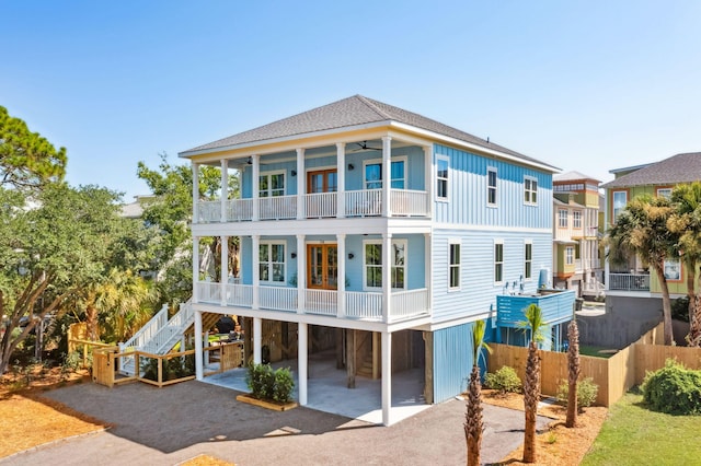 rear view of property featuring a carport, a balcony, covered porch, and ceiling fan