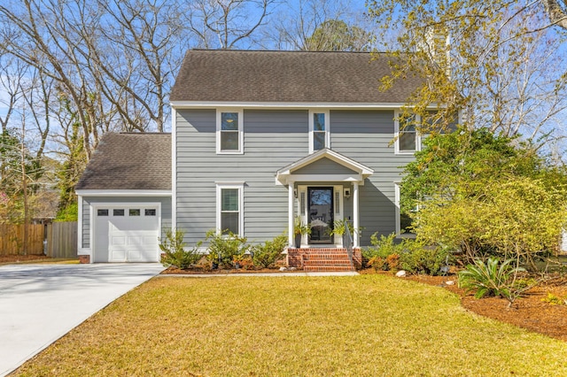 colonial home with a shingled roof, concrete driveway, an attached garage, a front yard, and fence