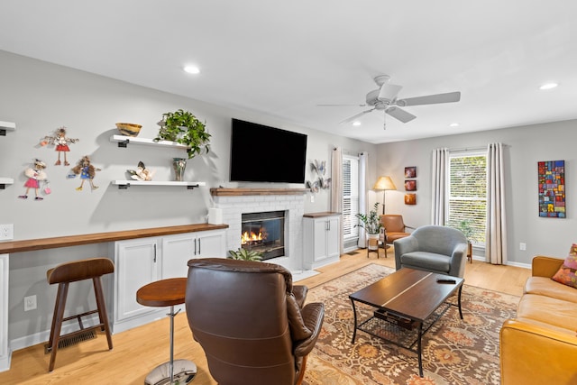 living area featuring a ceiling fan, recessed lighting, and light wood finished floors