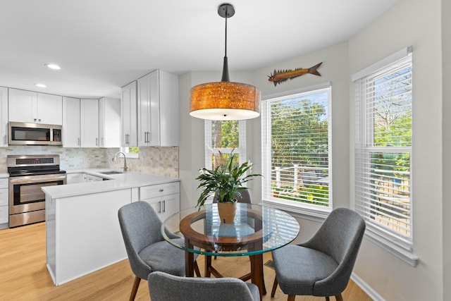 dining area with light wood-style floors, baseboards, and recessed lighting