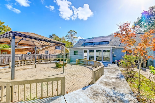 rear view of house with a gazebo, solar panels, central AC, and a wooden deck