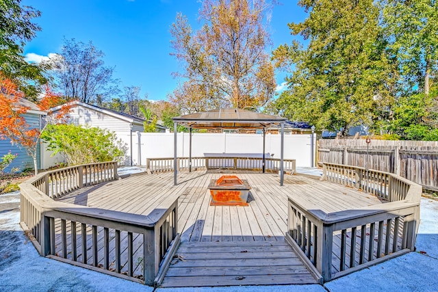 wooden deck featuring a gazebo and an outdoor fire pit