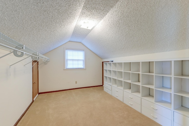 additional living space featuring lofted ceiling, a textured ceiling, and light colored carpet