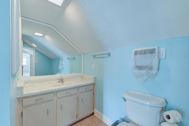 bathroom featuring a textured ceiling, toilet, tile patterned floors, vaulted ceiling, and vanity